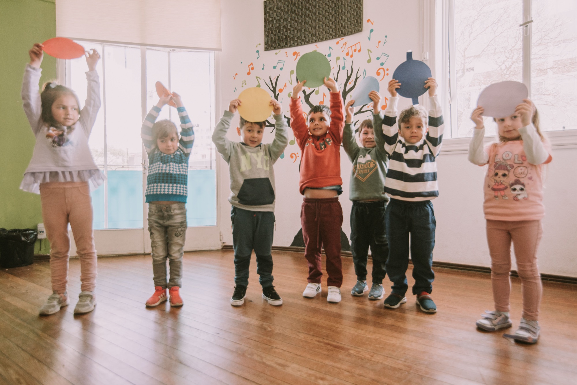Children in class holding up colourful paper cut-outs
